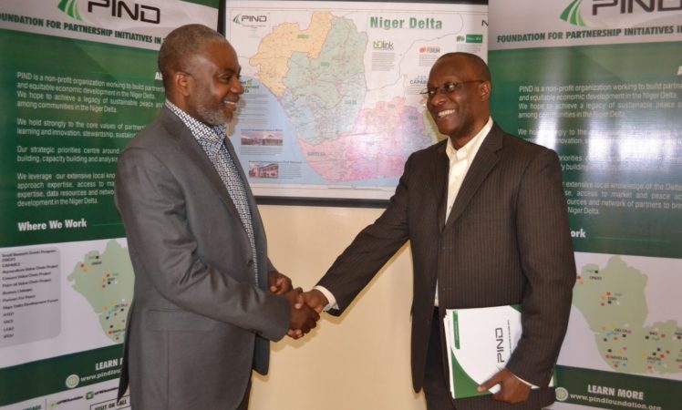 Outgoing Executive Director, Sam Daibo (left) shakes hands with his successor, Dr. Dara Akala (right) in a brief handover ceremony at the PIND office